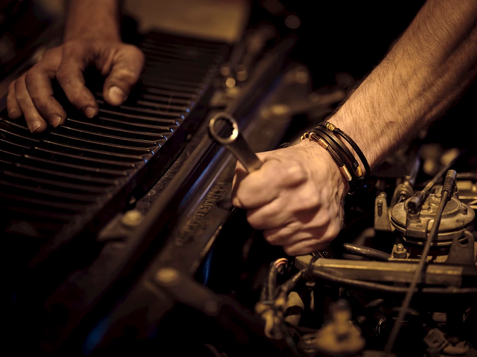 Imagem que mostra um macânico mexendo em um motor de carro