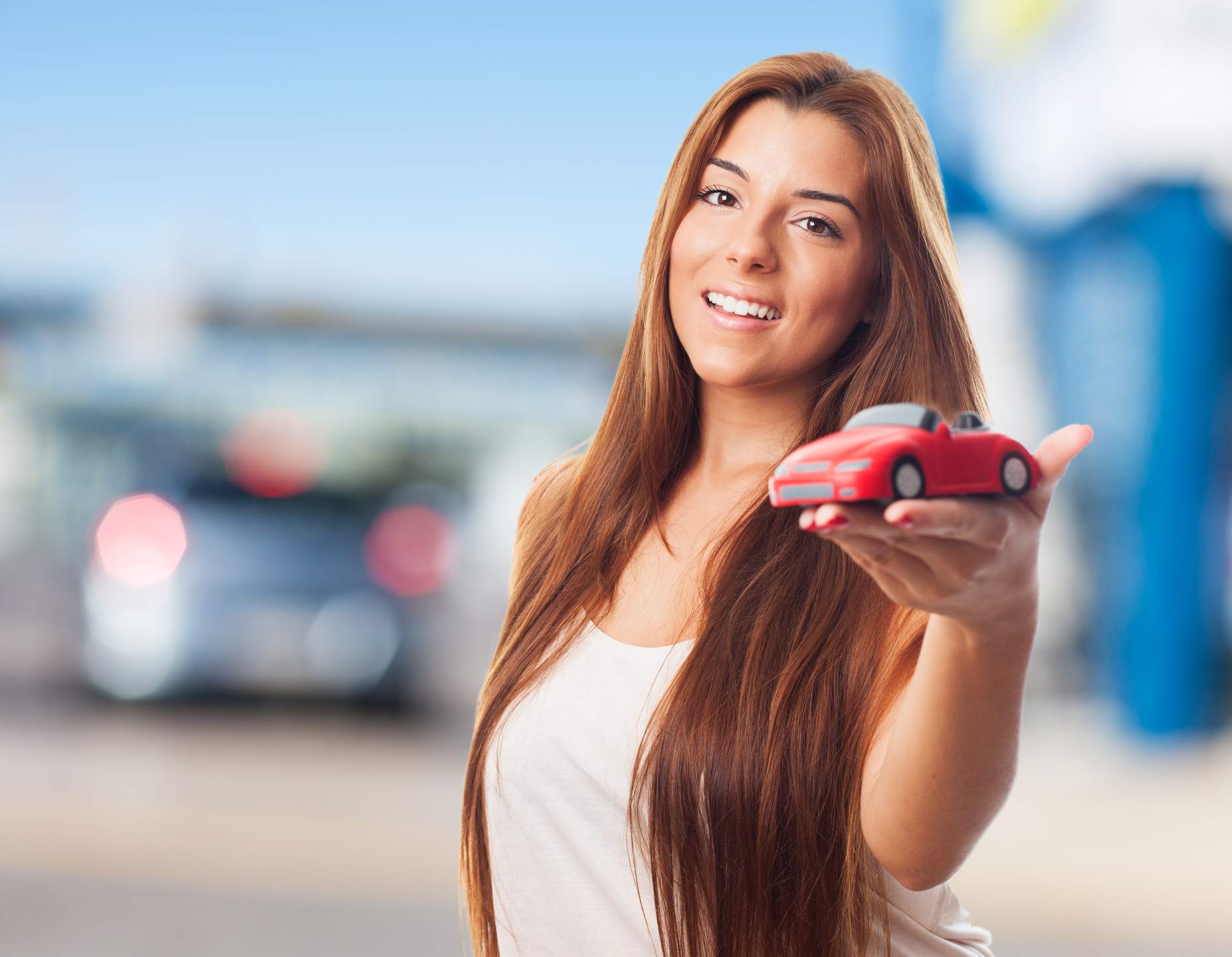 Somos a primeira oficina com certificação de Amiga da Mulher na zona sul de Porto Alegre Imagem que mostra uma Mulher Feliz segurando um carro de brinquedo.